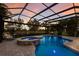 Inviting screened-in pool and spa area with a seating area, serene lake views, and a vibrant sunset sky at 13706 American Prairie Pl, Lakewood Ranch, FL 34211