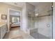 Elegant bathroom with tiled walk-in shower, bench, and view into the serene main bedroom at 13848 American Prairie Pl, Lakewood Ranch, FL 34211
