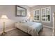 Comfortable bedroom with two shuttered windows, carpet, and en-suite bathroom at 13848 American Prairie Pl, Lakewood Ranch, FL 34211