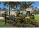 Charming home showcasing a lush, landscaped front yard with colorful plants and a paved walkway at 13848 American Prairie Pl, Lakewood Ranch, FL 34211
