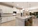 Modern kitchen with sleek countertops, stainless steel appliances, and a central island with stools at 13848 American Prairie Pl, Lakewood Ranch, FL 34211