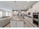 Spacious kitchen with white cabinets, stainless steel appliances, a large kitchen island and open floorplan at 13848 American Prairie Pl, Lakewood Ranch, FL 34211