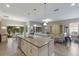 Open-concept kitchen with a large island, stainless steel appliances and a view of the living room and backyard at 13848 American Prairie Pl, Lakewood Ranch, FL 34211