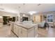 Open-concept living space featuring a kitchen island overlooking a cozy living room with entertainment center at 13848 American Prairie Pl, Lakewood Ranch, FL 34211
