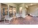Brick patio with comfortable seating, offering a view into the home's interior through sliding glass doors at 13848 American Prairie Pl, Lakewood Ranch, FL 34211