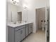 Bathroom featuring double sinks with quartz countertops, grey cabinets and tile flooring at 14314 17Th E Ct, Parrish, FL 34219