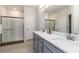 Bright bathroom featuring double sinks, quartz countertops, grey cabinets and glass shower at 14314 17Th E Ct, Parrish, FL 34219