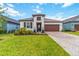 Charming single-story home with a well-manicured lawn and paver driveway leading to a two-car garage at 14314 17Th E Ct, Parrish, FL 34219