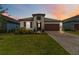 Charming single-story home with a well-manicured lawn and inviting curb appeal at sunset at 14314 17Th E Ct, Parrish, FL 34219