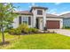 Charming single-story home with a well-manicured lawn and paver driveway leading to a two-car garage at 14314 17Th E Ct, Parrish, FL 34219