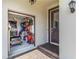 Open garage reveals storage and organization; entry door with exterior lamp at 14314 17Th E Ct, Parrish, FL 34219