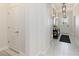 Bright, neutral hallway with console table, mirrors, overhead lighting, and a glimpse of the exterior at 14314 17Th E Ct, Parrish, FL 34219