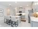 Contemporary kitchen features white cabinets, sleek island with bar stools and stainless appliances at 14314 17Th E Ct, Parrish, FL 34219