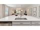 Close-up on a quartz island in a stylish kitchen, open to the living and dining areas at 14314 17Th E Ct, Parrish, FL 34219