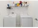Functional laundry room with side-by-side washer and dryer and overhead storage shelving at 14314 17Th E Ct, Parrish, FL 34219