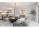 Bright and airy living room featuring a gray sectional, chandelier and a large mirror at 14314 17Th E Ct, Parrish, FL 34219