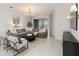 Bright living room featuring a large gray sectional sofa and a decorative chandelier at 14314 17Th E Ct, Parrish, FL 34219
