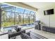 Inviting screened-in patio with comfortable seating, outdoor grill, and stunning pool and wooded views at 14314 17Th E Ct, Parrish, FL 34219
