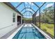 A screened-in pool with lounge chairs and an adjacent patio area offers outdoor living space at 14314 17Th E Ct, Parrish, FL 34219