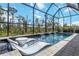 A screened-in pool area with lounge chairs and waterfall features offers relaxation and privacy at 14314 17Th E Ct, Parrish, FL 34219