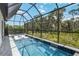 A screened-in pool with waterfall features provides a relaxing outdoor oasis at 14314 17Th E Ct, Parrish, FL 34219