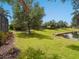Beautifully maintained backyard, complemented by a tranquil pond, verdant greenery, and mature trees, offering privacy at 14325 Stirling Dr, Lakewood Ranch, FL 34202