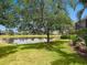 Lush green backyard view showcasing a peaceful pond and mature trees, perfect for relaxing and entertaining outdoors at 14325 Stirling Dr, Lakewood Ranch, FL 34202