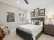 Cozy bedroom featuring a bed with gray and white patterned bedding, accent chair, and charming wall art at 14325 Stirling Dr, Lakewood Ranch, FL 34202