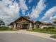 Exterior view of the clubhouse with stone accents, lush landscaping, and a grand entrance at 14325 Stirling Dr, Lakewood Ranch, FL 34202