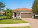 Charming single-story home showcasing a terracotta tile roof, brick driveway, and well-manicured lawn at 14325 Stirling Dr, Lakewood Ranch, FL 34202