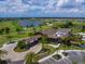 Aerial view of the club house overlooking a golf course and a lake, set against a background of lush greenery at 14325 Stirling Dr, Lakewood Ranch, FL 34202