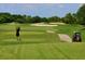 Active golfer on the green with a golf cart in the background with idyllic views of the course at 14325 Stirling Dr, Lakewood Ranch, FL 34202
