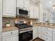 Gourmet kitchen boasts granite counters, stainless appliances, mosaic backsplash, and modern lighting fixtures at 14325 Stirling Dr, Lakewood Ranch, FL 34202