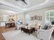 Bright living room with wood floors, ceiling fan, neutral furnishings, and a decorative wood coffee table at 14325 Stirling Dr, Lakewood Ranch, FL 34202