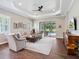 Inviting living room with wood floors, coffered ceiling, neutral decor, and a sliding glass door to the patio at 14325 Stirling Dr, Lakewood Ranch, FL 34202