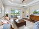Comfortable living room featuring a ceiling fan, wood floors, and a sliding door leading to the outdoor pool area at 14325 Stirling Dr, Lakewood Ranch, FL 34202