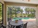 Screened-in pool area with a patio table and views of the beautiful landscaping at 14325 Stirling Dr, Lakewood Ranch, FL 34202