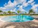 A large community pool with shallow water features, surrounded by lush landscaping and clear blue skies at 14325 Stirling Dr, Lakewood Ranch, FL 34202