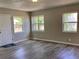 Neutral living room with gray flooring and plentiful windows, door with a Welcome mat at 1512 18Th W Ave, Bradenton, FL 34205
