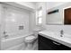 Bright bathroom features a white tiled shower and a vanity with modern fixtures at 15718 Squirrel Tree Pl, Tampa, FL 33624