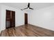 Bedroom boasts a ceiling fan, wood-look flooring, and closet with louvered doors at 15718 Squirrel Tree Pl, Tampa, FL 33624