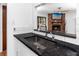 Granite countertops and stainless steel sink with view into the Gathering room with a brick fireplace at 15718 Squirrel Tree Pl, Tampa, FL 33624