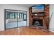 Bright living room featuring a brick fireplace, access to sunroom, and sleek wood flooring at 15718 Squirrel Tree Pl, Tampa, FL 33624