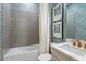 Bathroom features stylish blue wallpaper, tub with tile surround and modern fixtures at 16404 Isola Pl, Bradenton, FL 34211