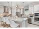Modern kitchen with stainless steel appliances, a large island, and pendant lighting at 16404 Isola Pl, Bradenton, FL 34211