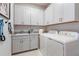 Laundry room equipped with modern washer, dryer, sink, and ample cabinet space at 16404 Isola Pl, Bradenton, FL 34211