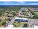 Wide aerial view of home in residential neighborhood with pond and blue apartment complex in the distance at 168 Wading Bird Dr, Venice, FL 34292