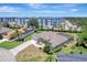 Aerial view of a home with neutral paint, with attached garage, pool, and mature landscaping at 168 Wading Bird Dr, Venice, FL 34292