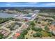 Wide aerial view of home in residential neighborhood with pond and blue apartment complex in the distance at 168 Wading Bird Dr, Venice, FL 34292