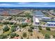 Wide aerial view of home in residential neighborhood with pond and blue apartment complex in the distance at 168 Wading Bird Dr, Venice, FL 34292